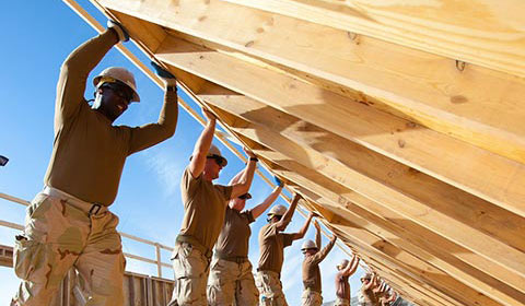 construction workers lifting a wall into place