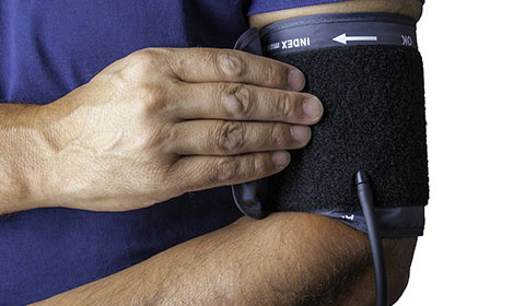 person taking his or her own blood pressure