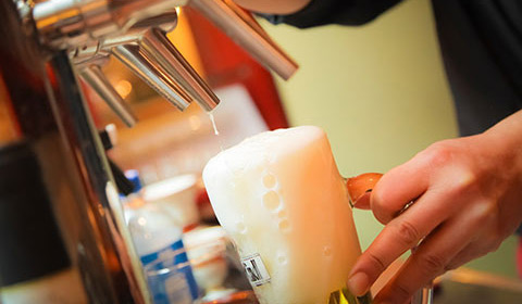 man pouring beer into mug