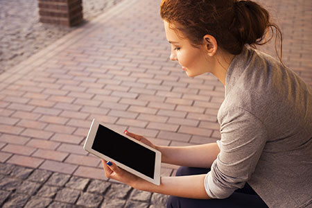 woman reading news on her mobile tablet device