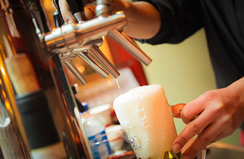 beer being poured from a tap into a mug